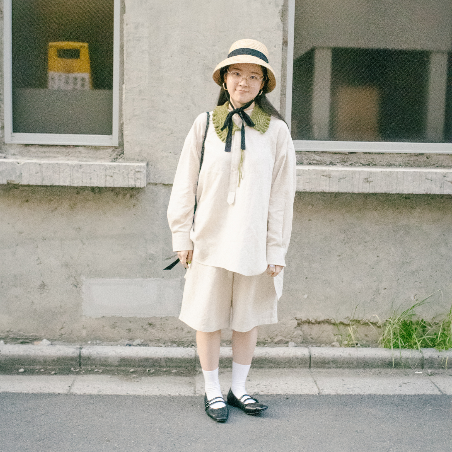 テンセルとコットンがまざったさわやかな生成色のセットアップを着る女性